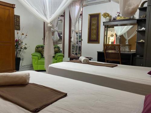 - une chambre avec deux lits et une chaise verte dans l'établissement Nola's Homestay, à Kampungdurian