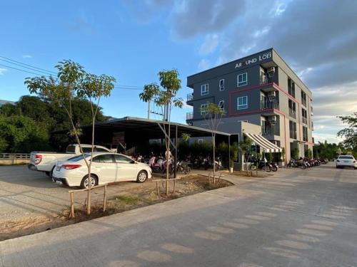 Around Loei في لووي: مبنى فيه سيارات متوقفة في موقف للسيارات