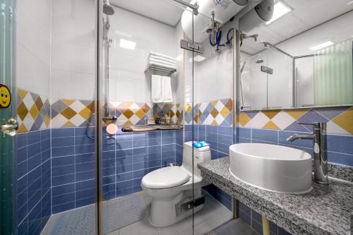 哈爾濱的住宿－新啟航賓館哈爾濱機塲店，浴室配有卫生间、盥洗盆和淋浴。