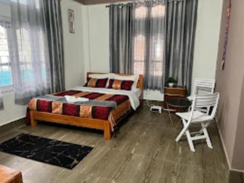 1 dormitorio con cama, escritorio y silla en Hotel Comfy Stay Tawang en Tawang