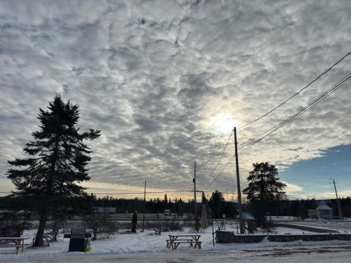 Un ciel nuageux avec une table de pique-nique dans la neige dans l'établissement Town and Country Motel, à Nipigon