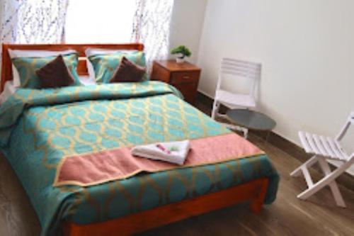 a bedroom with a bed with a chair and a table at Hotel Comfy Stay Tawang in Tawang