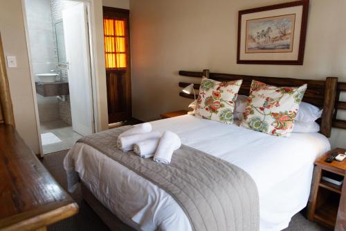 a bedroom with a bed with towels on it at Riverside Lodge & Conference Center in Aliwal North