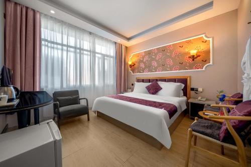 a hotel room with a large bed and a desk at Qihang Hotel Harbin Taiping Airport in Harbin