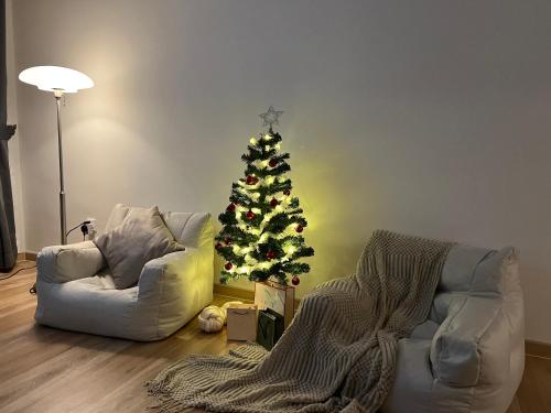a living room with a christmas tree and two chairs at Arte Cheras Designer Suite by Moka @ Cheras in Kuala Lumpur