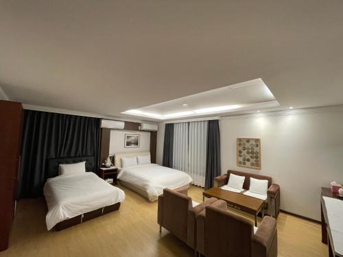 a hotel room with two beds and a desk at Hotel Terramar in Boryeong