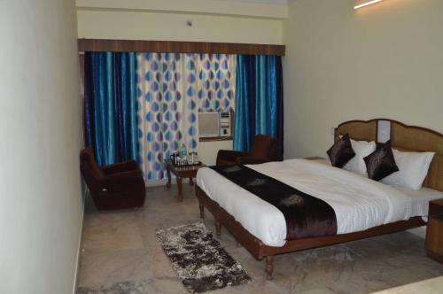 1 dormitorio con 1 cama, 1 silla y 1 ventana en Hotel Vinayakam, en Udaipur