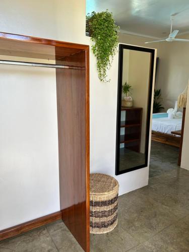 a mirror and a stool in a room with a bed at Yapak Beach Villas in San Isidro