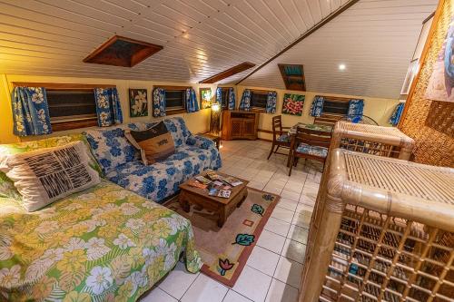 uma sala de estar com uma cama e um sofá em Heimanarii,slodge Tiare em Haapiti