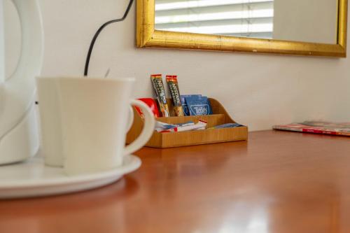 a table with a cup of coffee and a box of books at Broadway Boston in Cape Town