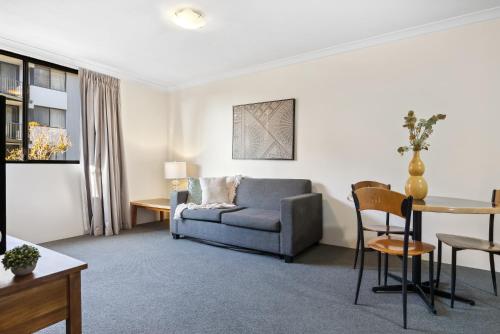 - un salon avec un canapé et une table dans l'établissement Riverside Elegance Central 1BR 1BA Apartment, à Perth