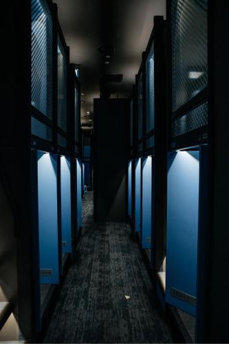 an empty hallway with blue doors in a building at CapsuleTransit Airside KLIA T2 - Airport Hotel - International Departure near to Transit Hall, Gate Q in Sepang