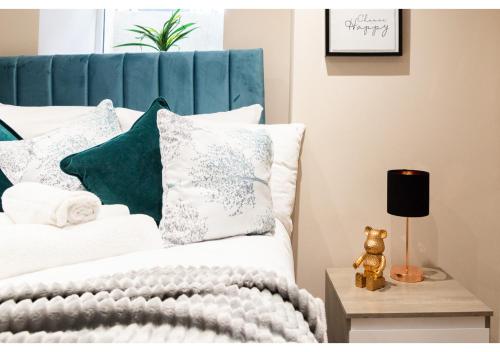 1 dormitorio con 1 cama con almohadas blancas y verdes en Experience Local: Quaint Studio in Cental Location, en Londres