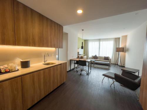 a kitchen with a sink and a living room at Holiday Inn San Luis Potosi-Quijote by IHG in San Luis Potosí