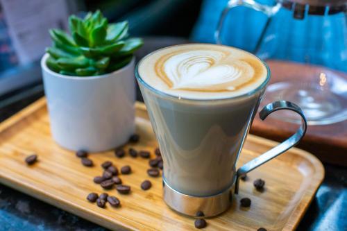 two cups of coffee on a tray with coffee beans at DoubleTree by Hilton Guangzhou - Canton Fair Free Shuttle Bus & Exhibition Registration Service in Guangzhou