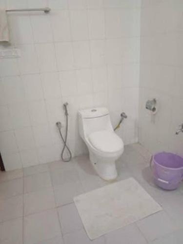 a bathroom with a toilet and a purple bowl at Hotel Saramati Dimapur in Dimāpur