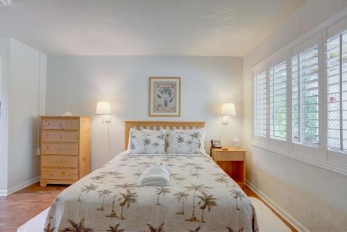 a bedroom with a bed and two windows at Tequesta Palms Inn in Tequesta