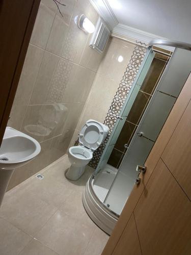 a bathroom with a toilet and a glass shower at Ecemsuit2 in Yomra