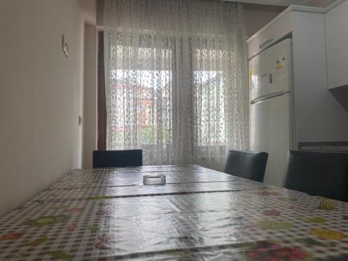 een keuken met een tafel met stoelen en een koelkast bij Ecemsuit in Yomra