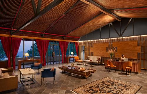 a large living room with tables and chairs at Storii By ITC Hotels, The Kaba Retreat, Solan in Solan