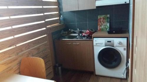 a kitchen with a washing machine and a sink at Residence R Hotel in Daegu