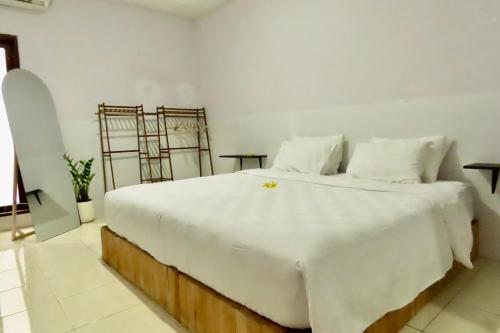 een slaapkamer met een groot wit bed met witte lakens bij Cozy House in Canggu in Dalung
