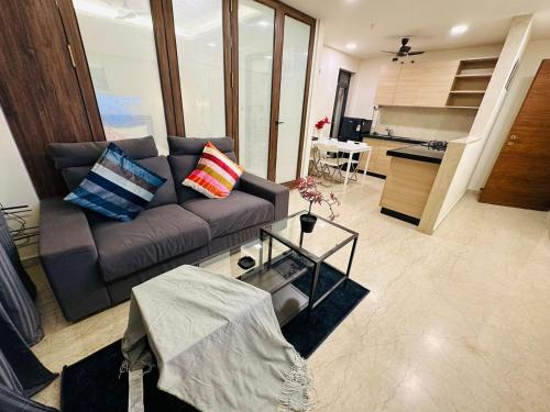 ein Wohnzimmer mit einem Sofa und einer Küche in der Unterkunft 1BR Service apartment in BKC by Florastays in Mumbai