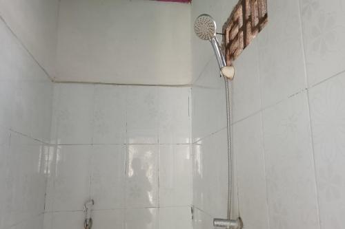 eine Dusche im Bad mit Duschkopf in der Unterkunft OYO 93359 Kawi Homestay in Praya