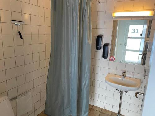a bathroom with a sink and a shower curtain at Motel Viborg in Viborg