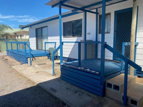a house with a blue porch with a swing at Sunset View in Point Turton