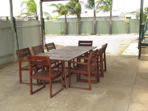a wooden table with wooden chairs and a wooden table and chairs at Sunset View in Point Turton