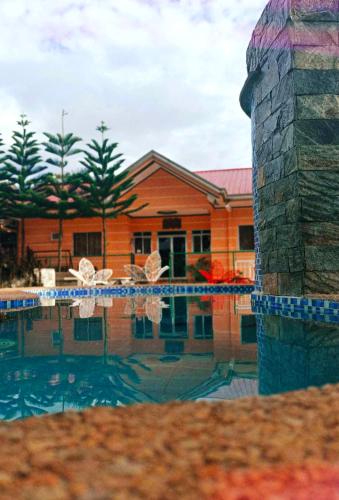 a house with a swimming pool in front of a house at OLAYN RESORT in Tagaytay