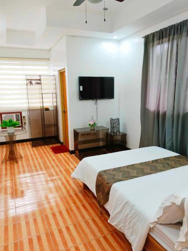 a bedroom with two beds and a flat screen tv at OLAYN RESORT in Tagaytay