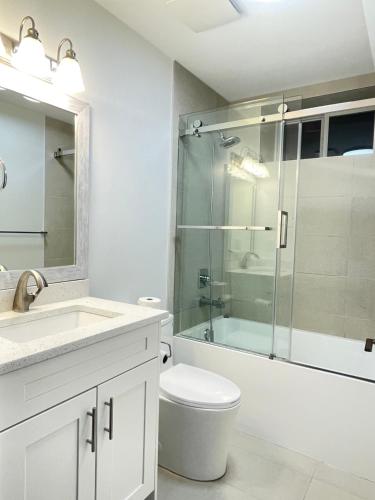 a bathroom with a toilet and a glass shower at south vancouver guesthouse in Vancouver