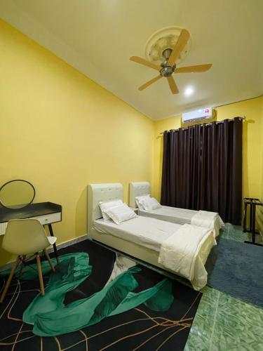Schlafzimmer mit einem Bett und einem Deckenventilator in der Unterkunft HOMESTAY Teratak Besut (HA) in Kampung Raja