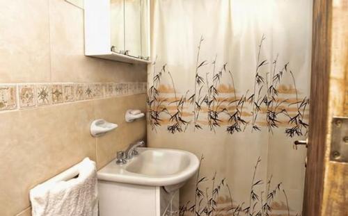 y baño con lavabo, aseo y cortina de ducha. en Cabañas Villa Lounge en San Rafael