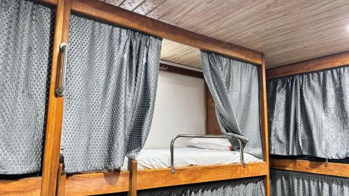 - une chambre avec 2 lits superposés et des rideaux dans l'établissement Kailasha - Hostel Cum PG, à Mumbai