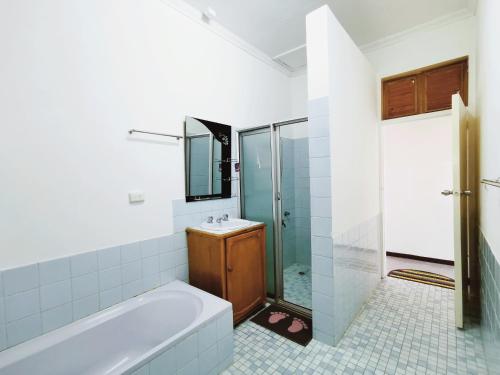 a bathroom with a tub and a sink and a shower at 机场附近的民宿B in Nadi