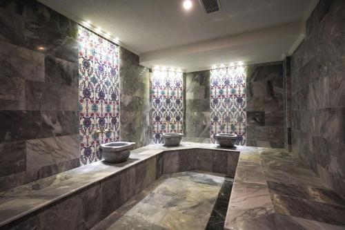 a bathroom with three sinks and stained glass windows at Ugurlu Hotel in Gaziantep