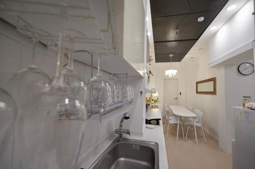 Soo Guest House في سول: مطبخ مع حوض ومكتب مع أكواب على الحائط
