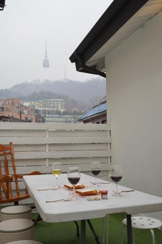 a white table with wine glasses on a balcony at Soo Guest House in Seoul