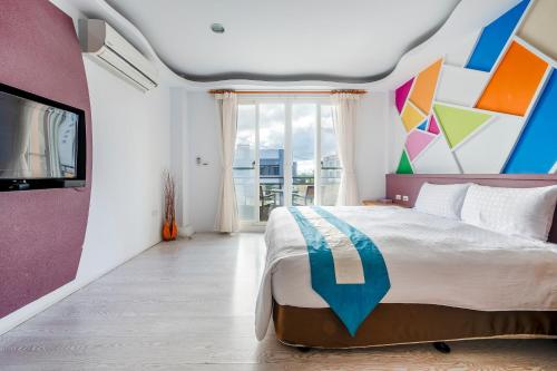 a bedroom with a large bed with a colorful wall at Wei Yuan Hotel in Kenting