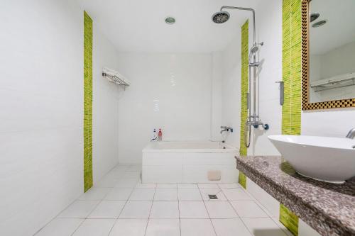 a bathroom with a white tub and a sink at Wei Yuan Hotel in Kenting