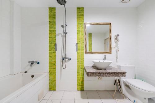 a bathroom with a sink and a toilet and a mirror at Wei Yuan Hotel in Kenting