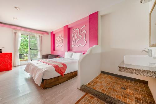 a bedroom with a bed and a bathroom with a sink at Wei Yuan Hotel in Kenting