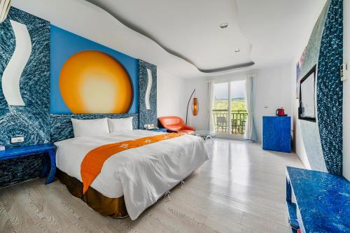 a bedroom with a bed with an orange and blue wall at Wei Yuan Hotel in Kenting