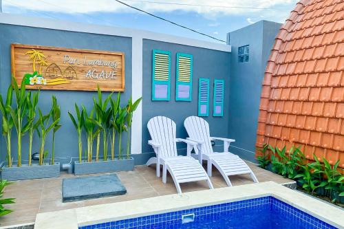 a patio with two chairs and a table and a pool at The Lavana Puri Lumbung Agave - Minimum stay 30 nights in Canggu