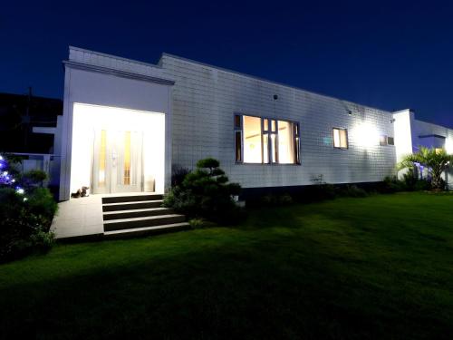 a house with a lit up door in a yard at 九十九里 SURF SIDE DOGRUN HOUSE in Katakai