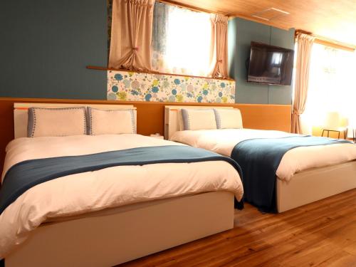 two beds sitting next to each other in a bedroom at 九十九里 SURF SIDE DOGRUN HOUSE in Katakai