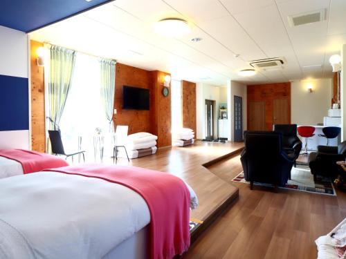 a hotel room with a bed and a living room at 九十九里 SURF SIDE DOGRUN HOUSE in Katakai